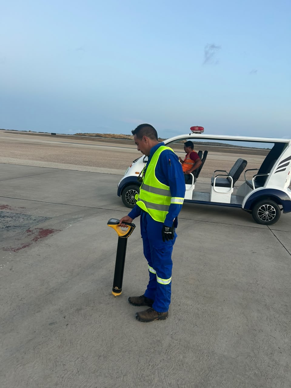 Profesional utilizando un localizador portátil en una zona pavimentada.